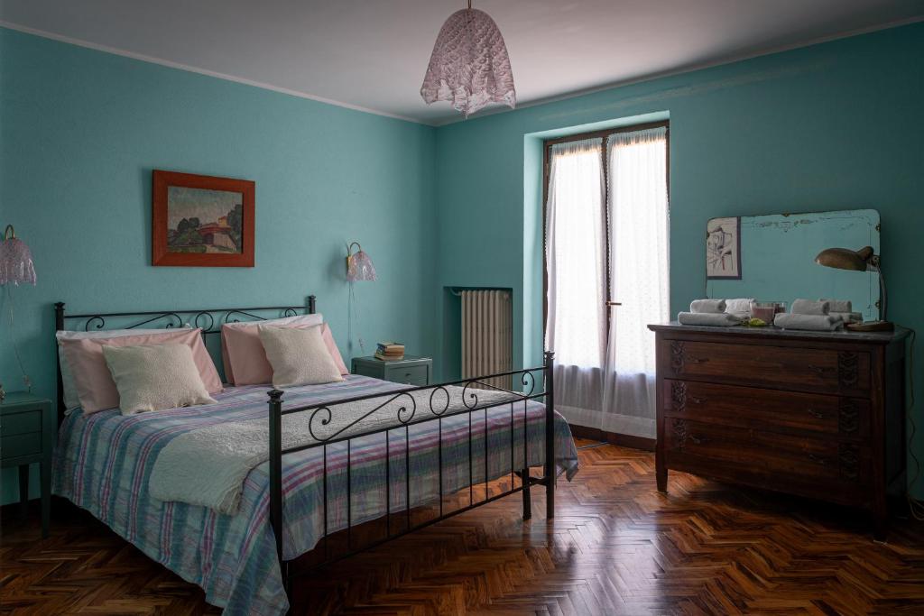 um quarto com paredes azuis, uma cama e uma cómoda em Casa Morè em Camo