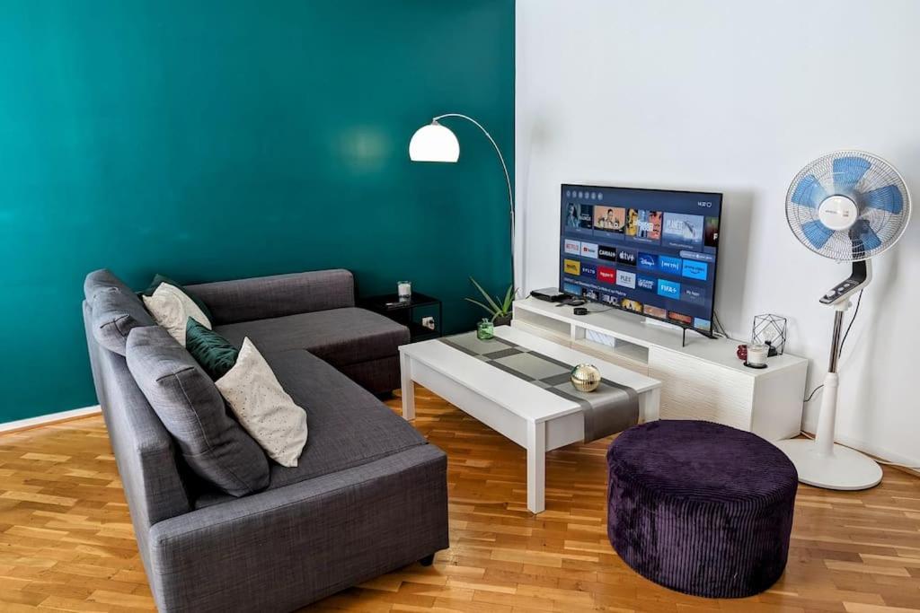 een woonkamer met een bank en een flatscreen-tv bij Séjour en famille ou amis à Disneyland & Paris in Lognes