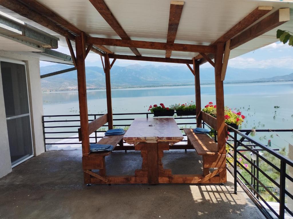 una mesa en un porche con vistas al agua en Apartmant Lidija en Nov Dojran