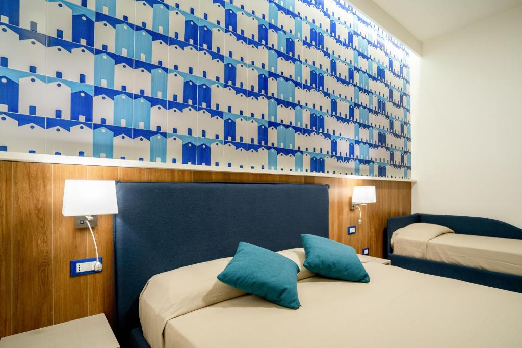 una camera d'albergo con due letti e una parete blu di Cuore di Minori a Minori