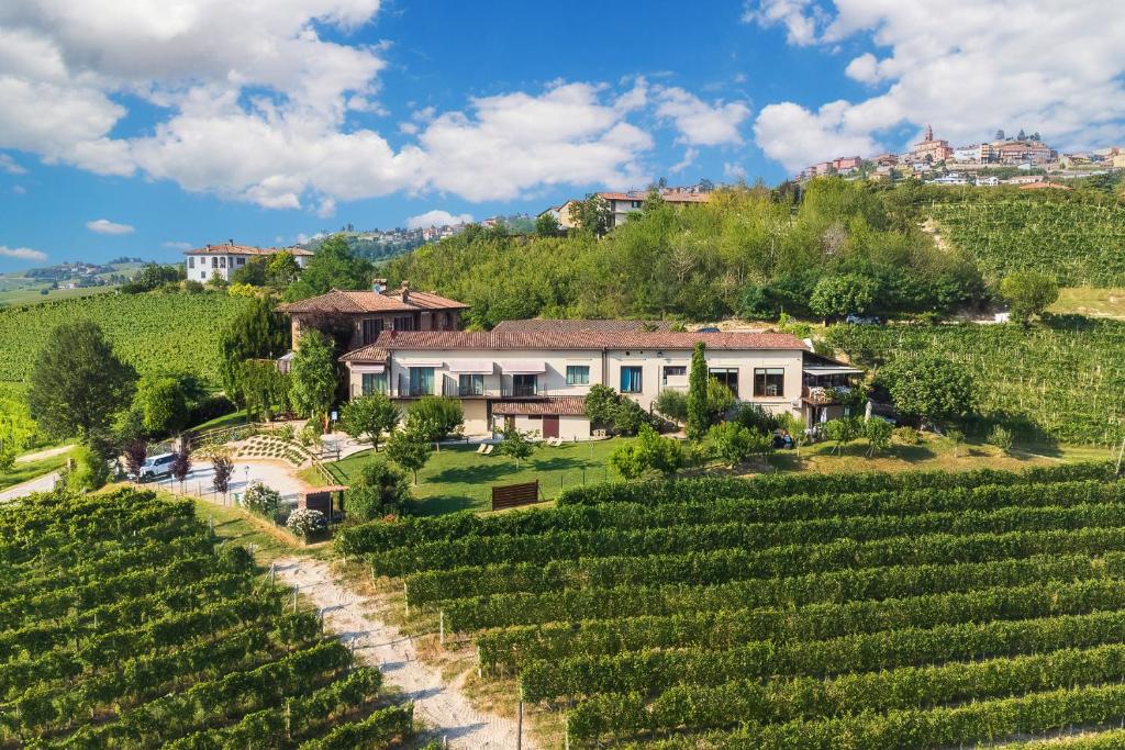 a house on a hill next to a vineyard at Il Cortile Suites in Diano dʼAlba
