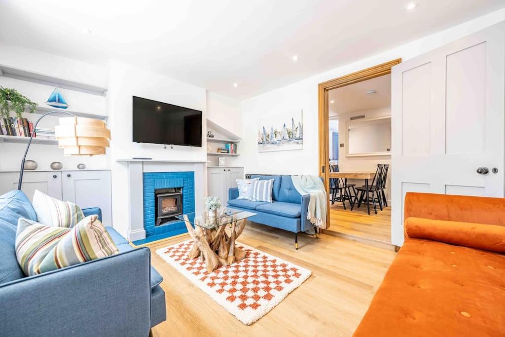 a living room with a blue couch and a table at The Lymington Sailor's Cottage in Lymington