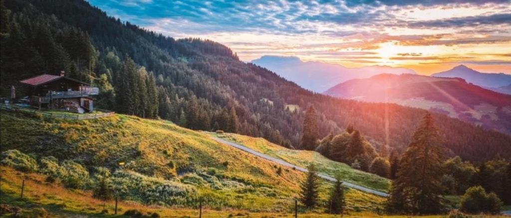 una montaña con una casa en la cima de una colina en Almhütte Andrea en Wildschönau