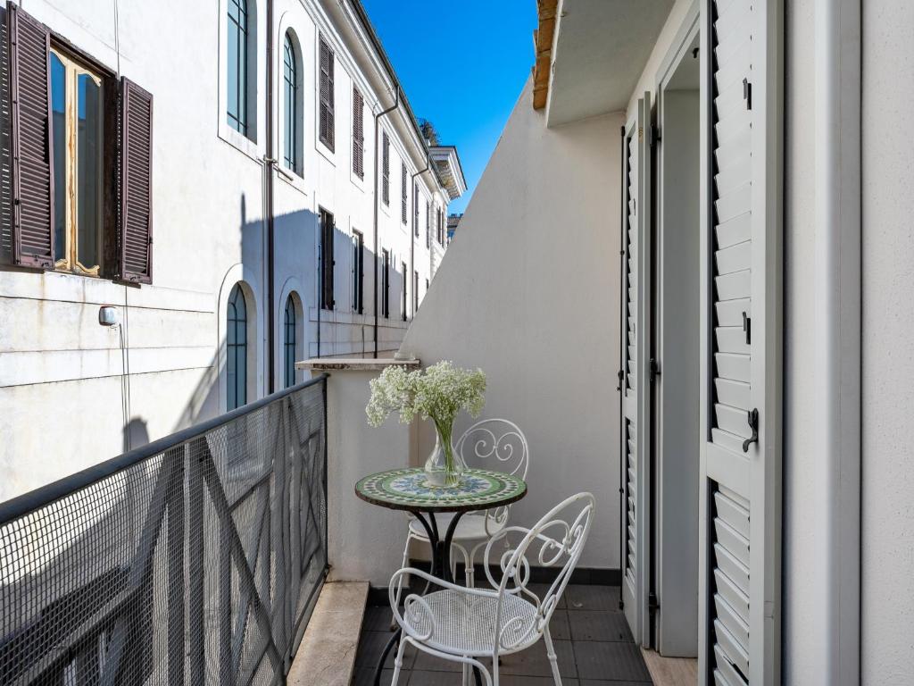 mały balkon ze stołem i krzesłami w obiekcie numa I Vici Rooms & Apartments w Rzymie