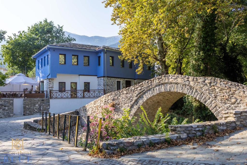 a blue house with a stone bridge and a blue building at Moustheni Blue Guest House in Mousthéni
