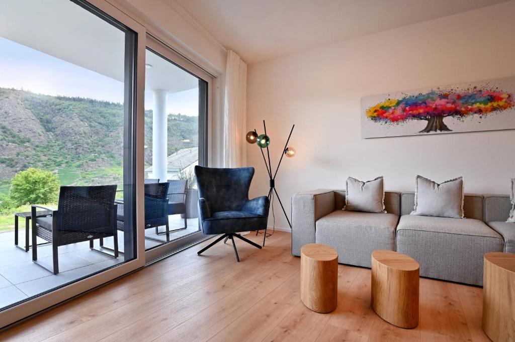 ein Wohnzimmer mit einem Sofa, einem Tisch und Stühlen in der Unterkunft Villa Bella Mosella in Cochem