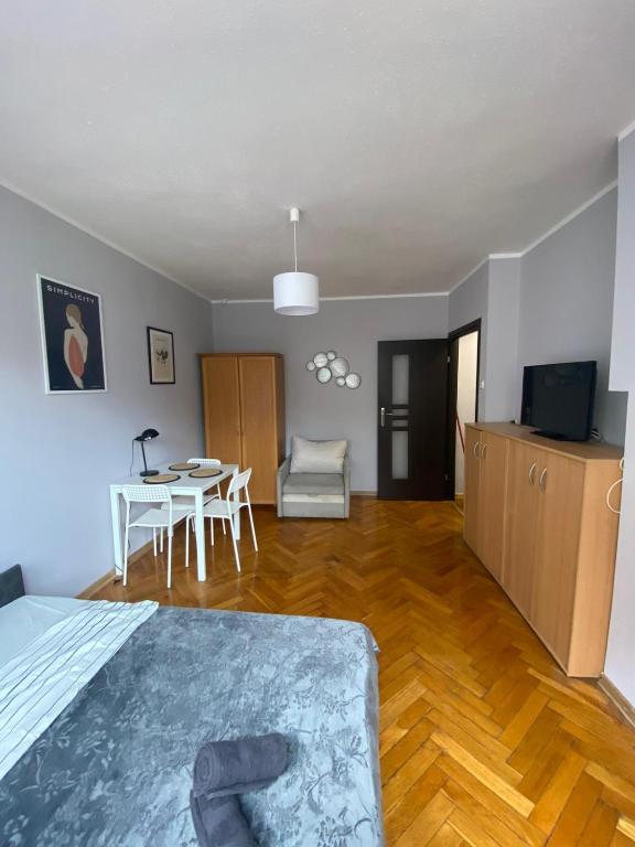 1 dormitorio con cama, mesa y comedor en Night Host Matejki 4, en Bytom