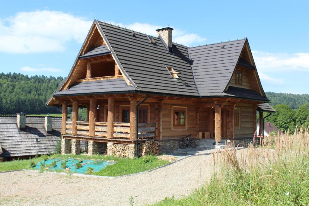 a large wooden house with a black roof at Wilk u Drzwi in Ustrzyki Dolne