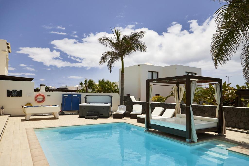 a swimming pool in a yard with a house at Villa Bella Valen - LH170 By Villas Now Ltd in Playa Blanca