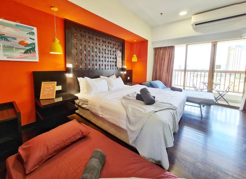 - une chambre avec un grand lit et un mur orange dans l'établissement Sunway Lagoon Sweet Comfy Home for 1-5pax, à Petaling Jaya