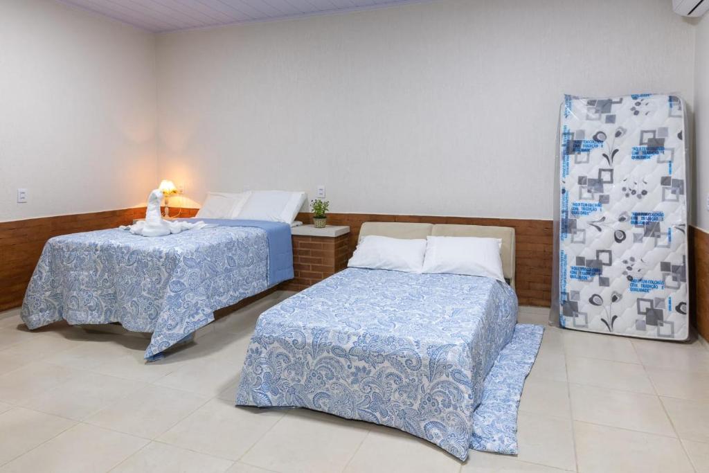 sypialnia z 2 łóżkami, stołem i oknem w obiekcie Rifugio w mieście Alto Paraíso de Goiás