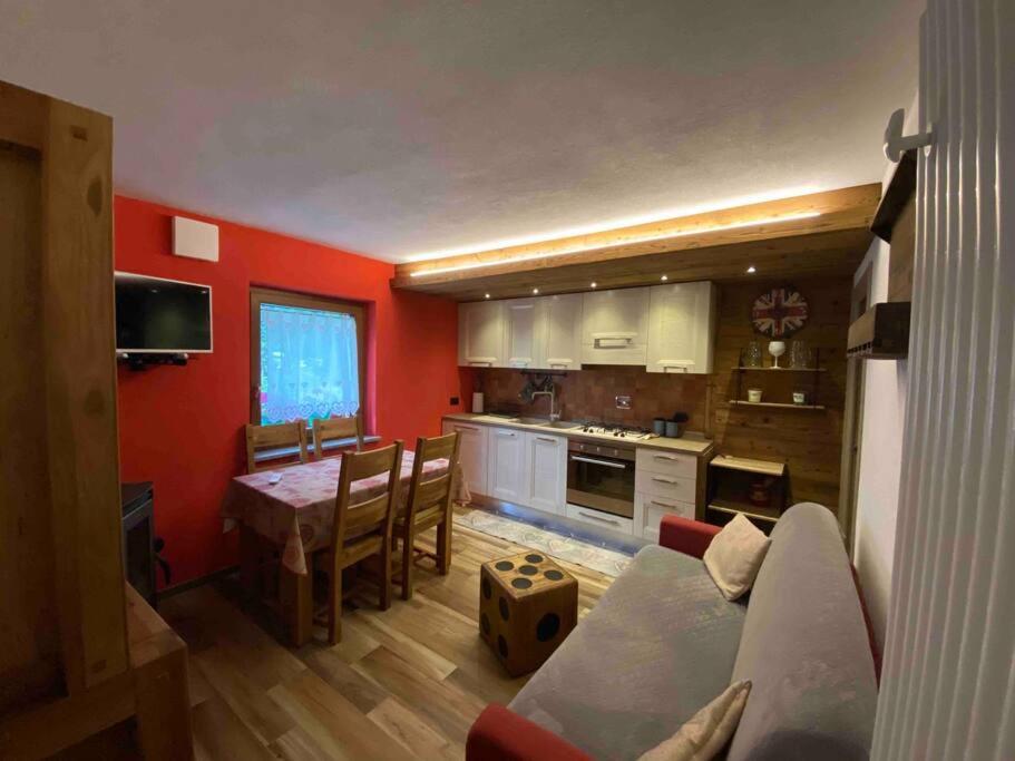 a kitchen with a couch and a table in a room at Appartamento sul Lago di Maen in Valtournenche