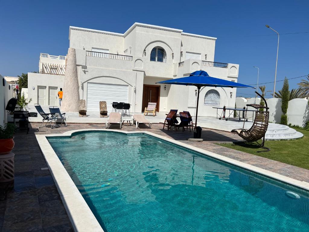a swimming pool in front of a house at VillaLina Haut Standing Djerba in Ajim