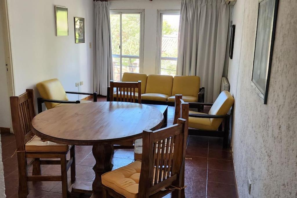 a living room with a wooden table and chairs at CERCA DE TODO amplio in Mendoza