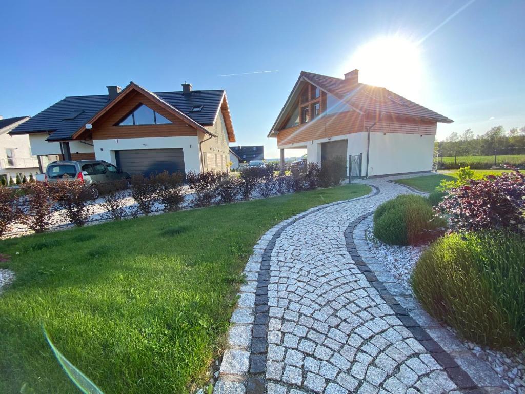 a house with a cobblestone driveway next to a house at Apartamenty Eksploris in Kudowa-Zdrój