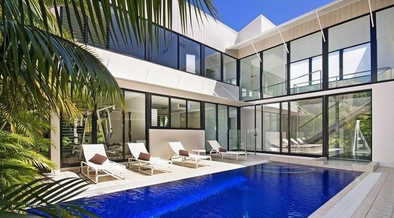 a large house with a swimming pool in front of it at Cascade, 15 Witta Circle, Noosa Heads in Noosa Heads