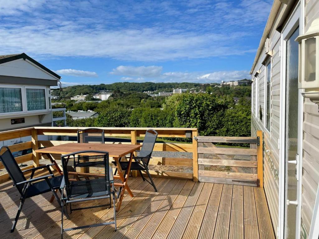 a wooden deck with a table and chairs on it at Holiday Home by the sea in Aberystwyth
