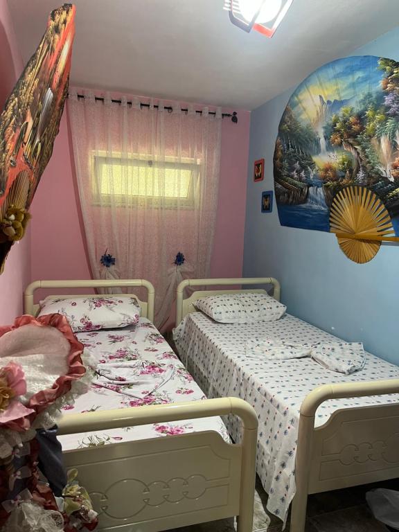 2 Betten in einem Zimmer mit Wandgemälde in der Unterkunft Sisi casa vacanze in Shkodra