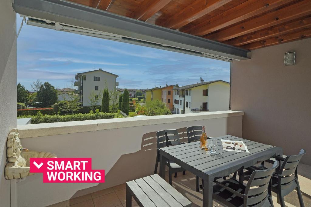 a table and chairs on a balcony with a view at Garofano P1-9 by Wonderful Italy in Desenzano del Garda