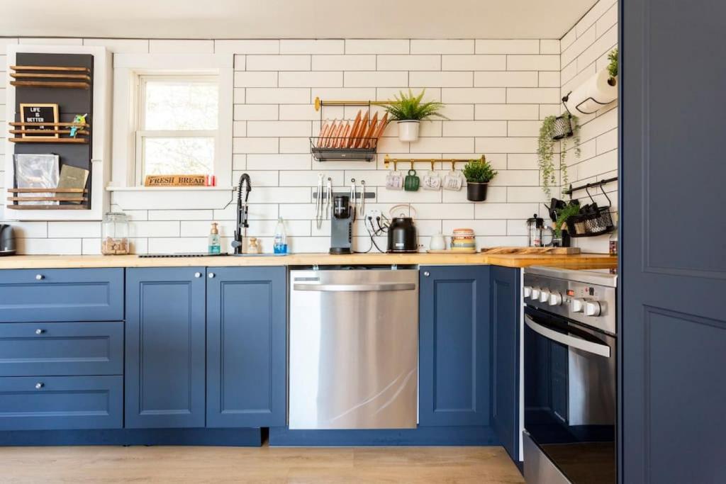 a kitchen with blue cabinets and white tiles at The Old Kettle Cabin with Hot Tub in Mill Village