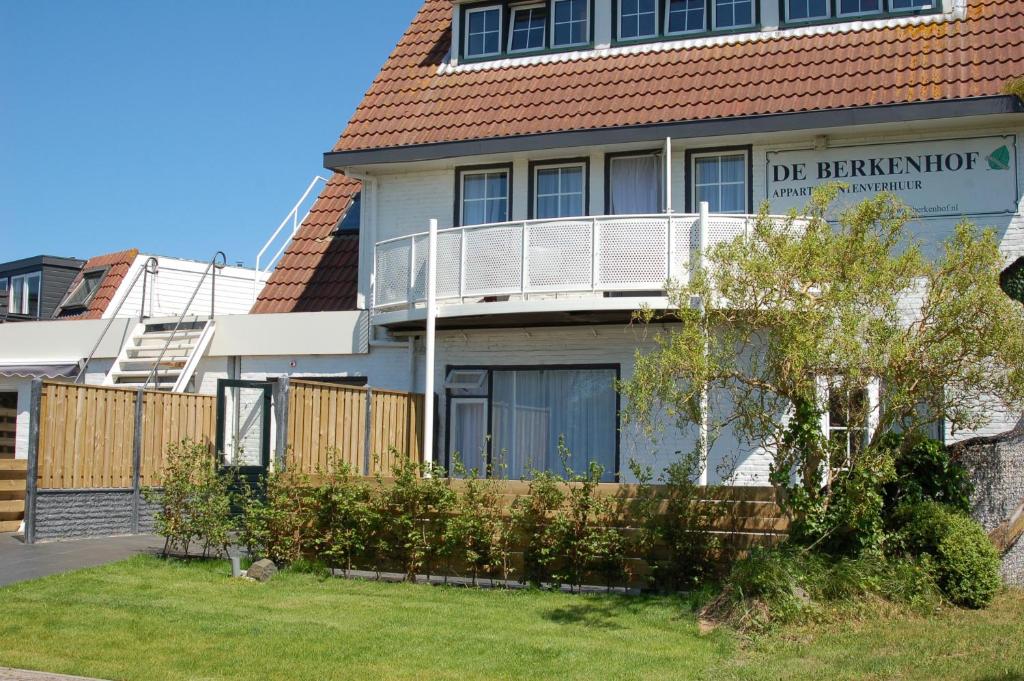 a house with a balcony on top of it at De Berkenhof in Nes