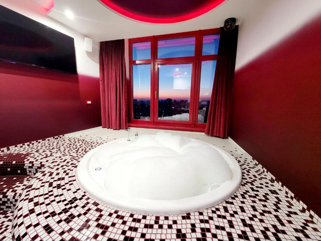 a bath tub in a bathroom with a window at Odessa arkadiya 4 room and Jacuzzi Lux in Odesa