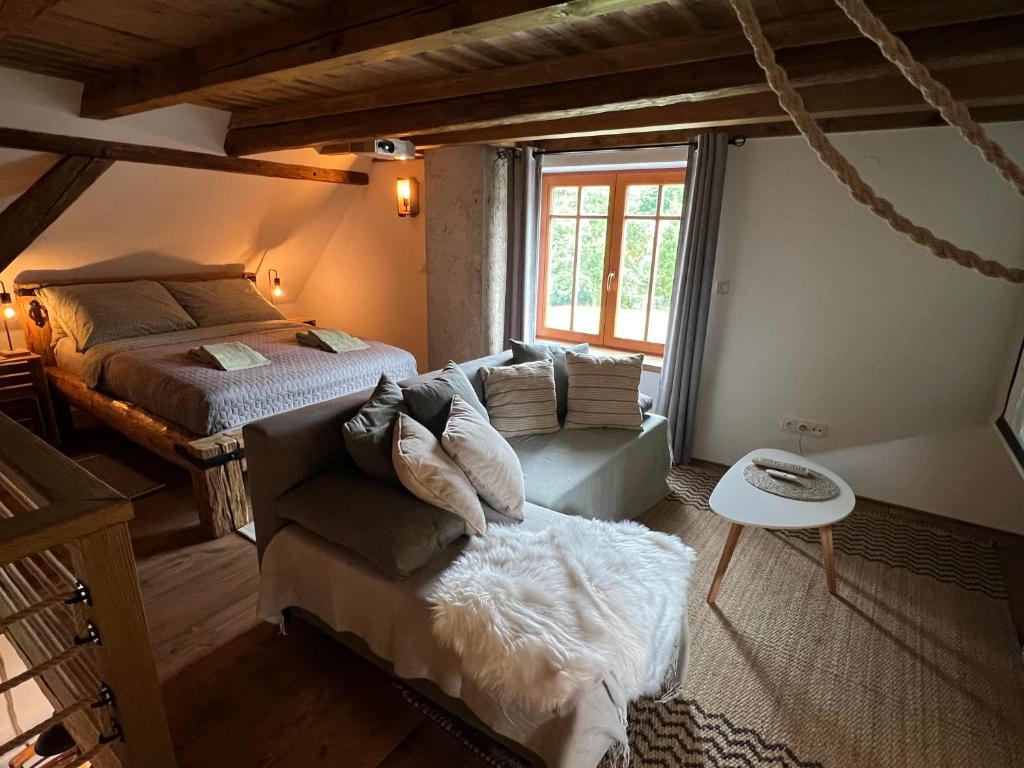 een slaapkamer met een bed, een bank en een raam bij Little Cottage No.100 in Vidochov