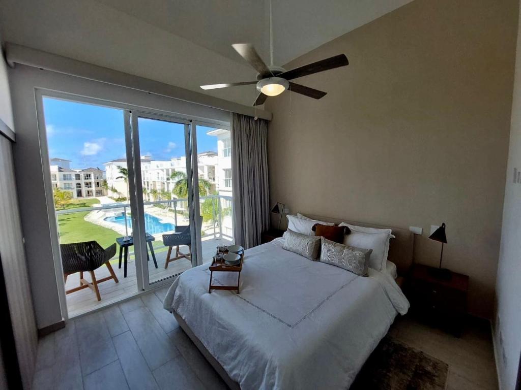 een slaapkamer met een bed en een plafondventilator bij Unique lake, Golf & Jacuzzi in Hard Rock Golf PC in Punta Cana