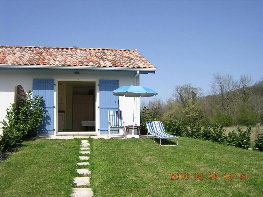 Escos的住宿－Gîte Le Trèfle Studioescos，蓝色的房子,配有椅子和雨伞