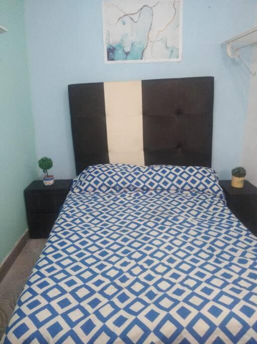 łóżko z niebiesko-białą kołdrą w sypialni w obiekcie Recámara comodísima y pequeña w mieście Monterrey