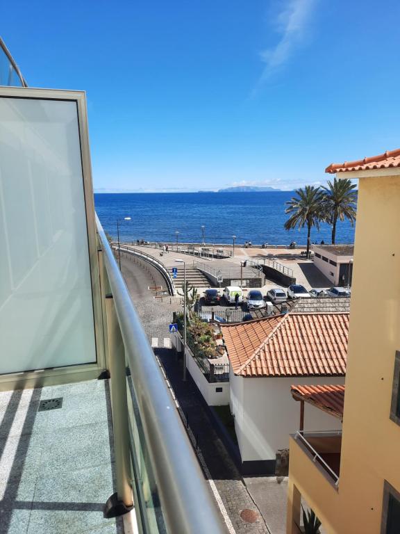 a view of the ocean from the balcony of a building at Sunny Beach Machico Apartment by HR Madeira in Machico