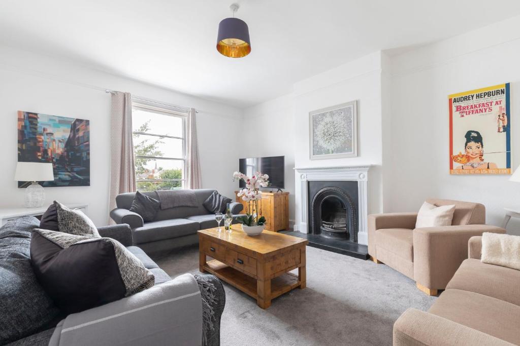 a living room filled with furniture and a fireplace at Fabulous, vibrant, town house, central Bath Road in Cheltenham