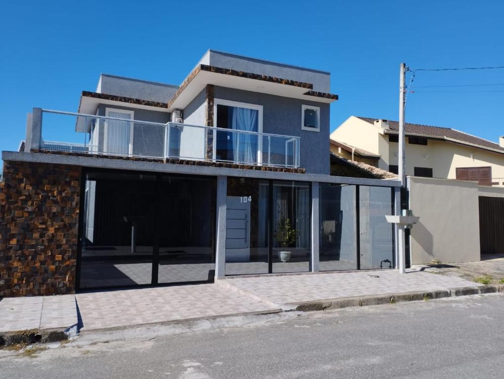 a house with a balcony on the side of a street at Sobrado com 3 quartos piscina 100m mar em matinhos in Matinhos