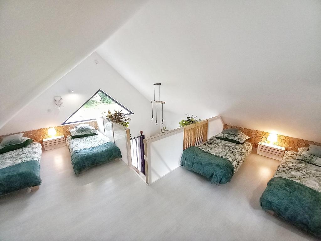a attic bedroom with three beds and a mirror at Eleonor Accommodation in Liszki