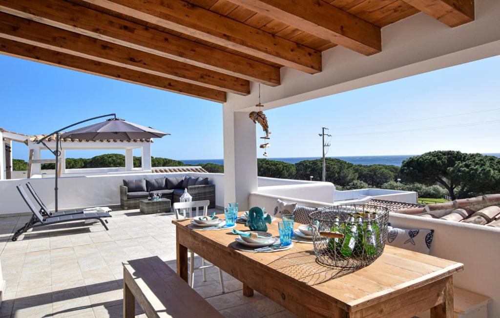 a patio with a wooden table on a roof at La Casa dei Pesci in Budoni