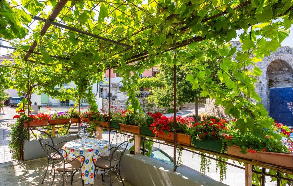- une terrasse avec une table, des chaises et des fleurs dans l'établissement Beautiful Apartment In Kastav With House A Panoramic View, à Kastav