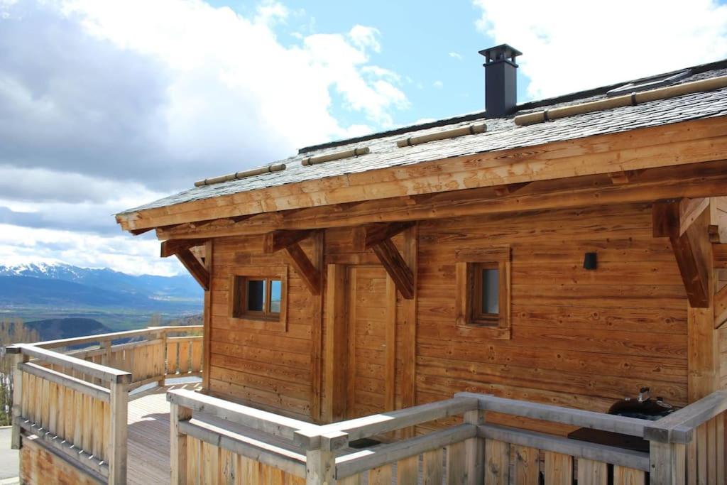 a log cabin with a cat sitting on the deck at Chalet Niyama in Font-Romeu-Odeillo-Via