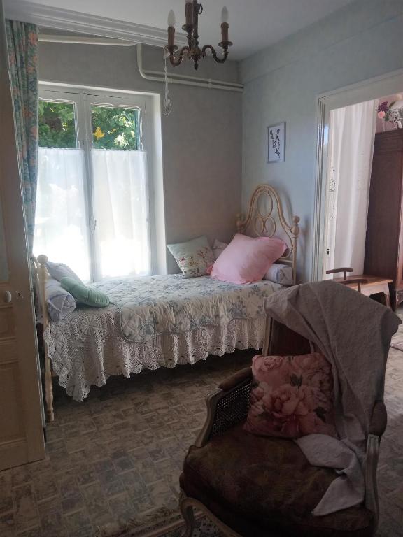 une chambre avec un lit, une chaise et une fenêtre dans l'établissement Rosalie Cottage, à Beaurepaire