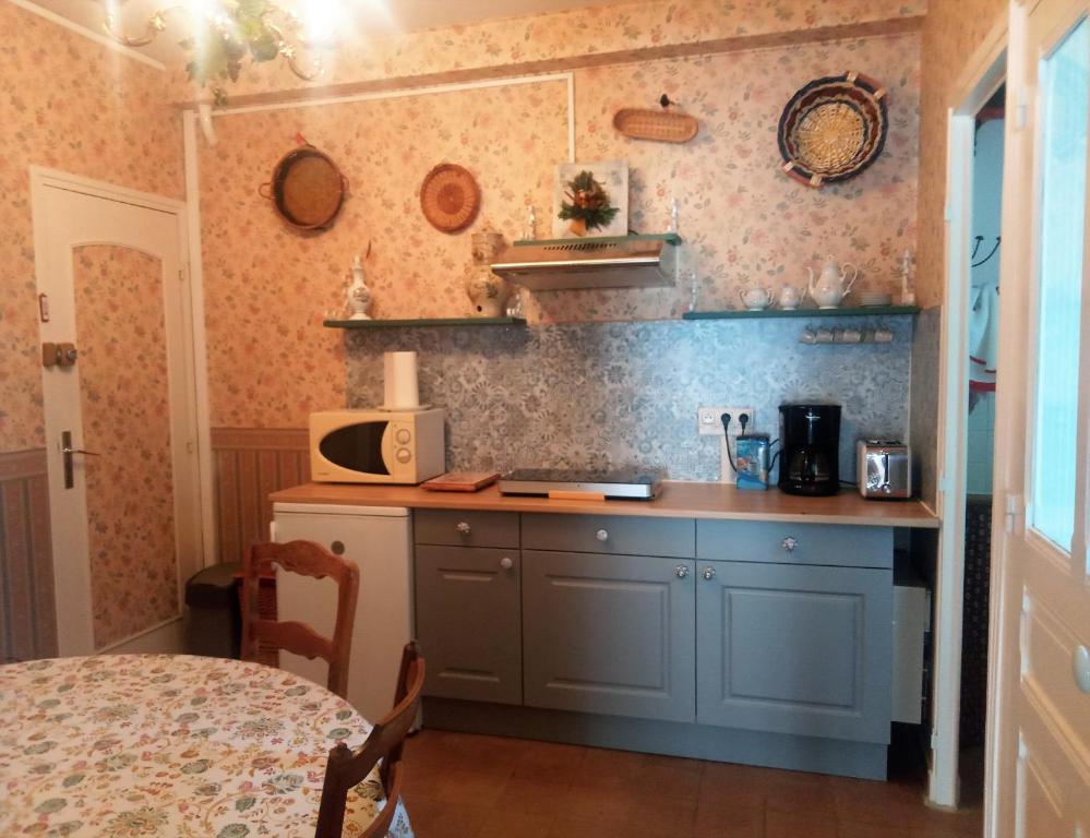 a kitchen with a counter with a microwave on the wall at Rosalie Cottage in Beaurepaire