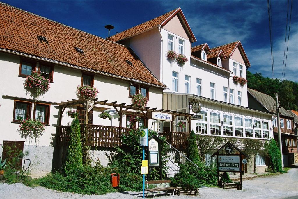 um grande edifício branco com uma placa em frente em Hotel Weißes Roß em Altenbrak