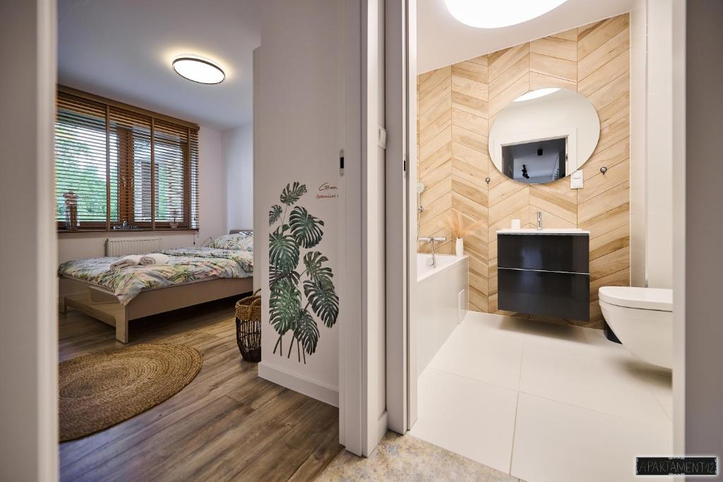 een badkamer met een bed, een wastafel en een spiegel bij Apartament 12 in Chojnice