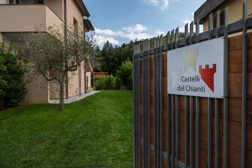 un panneau sur une clôture à côté d'une cour dans l'établissement Castelli del Chianti, à Gaiole in Chianti