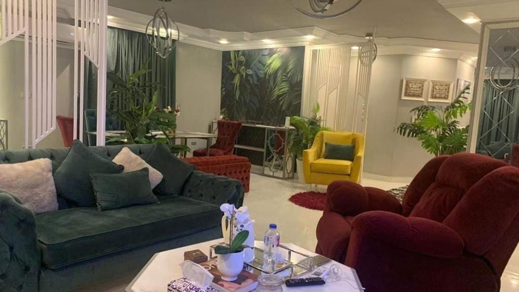 een woonkamer met een groene bank en stoelen bij شقق فندقيه فاخره in Kafr Abū ʼumaydah