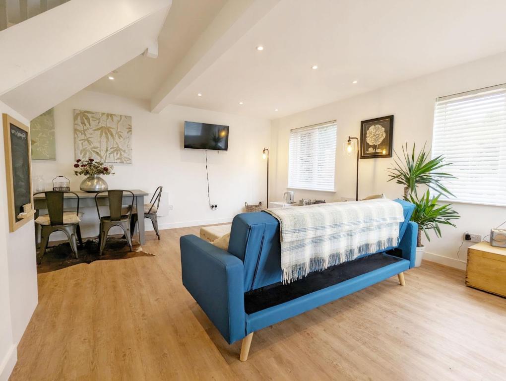 ein Schlafzimmer mit einem blauen Sofa und einem Esszimmer in der Unterkunft The Gofflet, Petworth in North Chapel