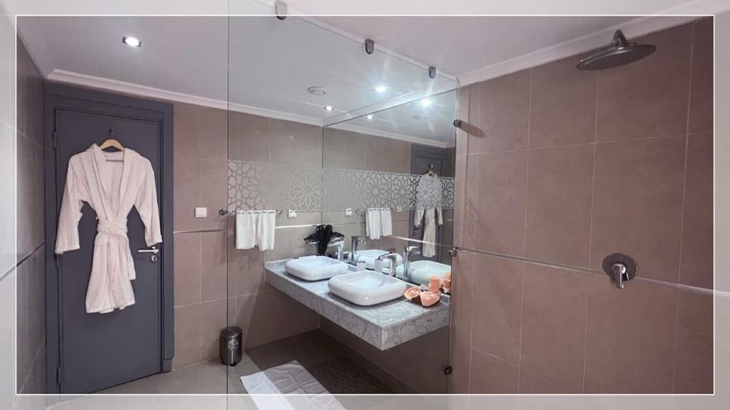 une salle de bain avec un lavabo et un miroir dans l'établissement Hotel Al Massira, à Laâyoune