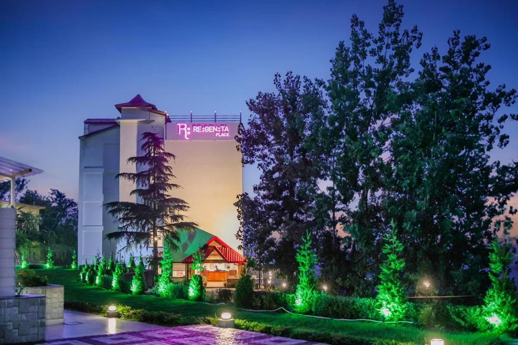 a resort with green lighting in front of a building at Regenta Resort MARS Valley View Shoghi in Shimla