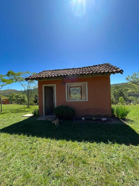 a small house in the middle of a field at Chalés Sitío dos Ventos in Lavras Novas