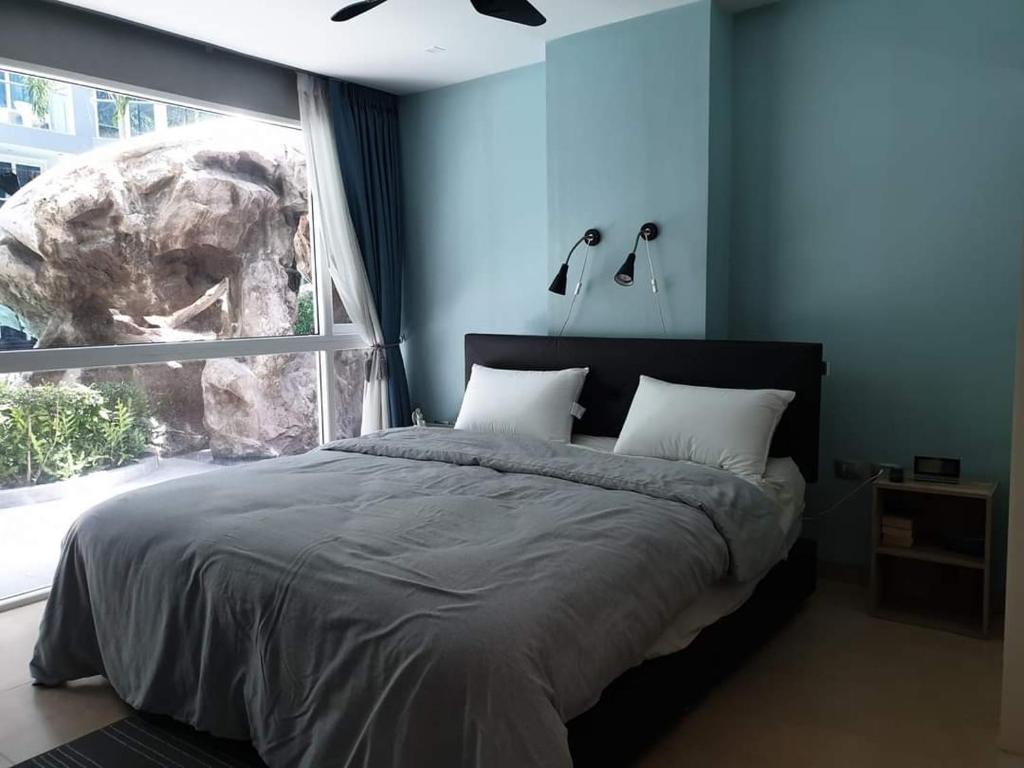 a bedroom with a bed with a large window at Centara Avenue 2 Bedrooms Pool View in Pattaya Central