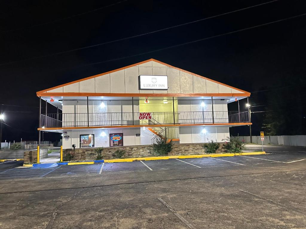 a parking lot in front of a building at night at Luxury Inn in Montgomery