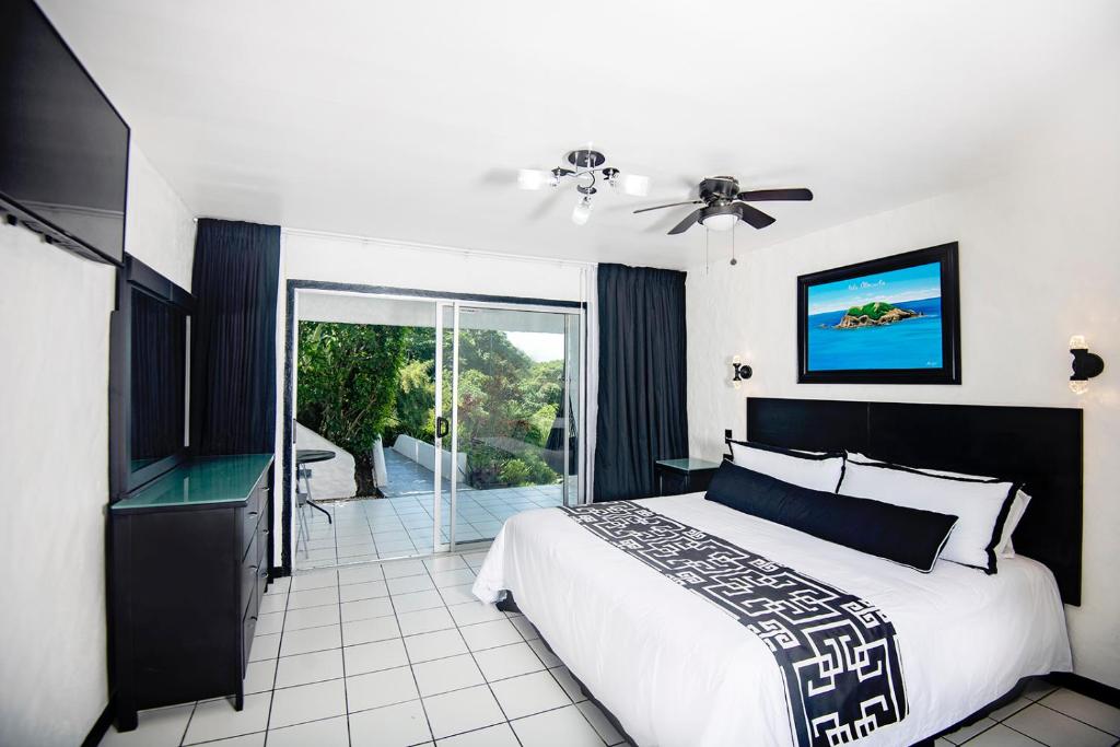 a bedroom with a bed and a sliding glass door at Villa Roca Boutique Resort & Suites - ADULT ONLY in Manuel Antonio